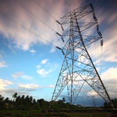 Mammoth power lines with blue sky and clouds behind