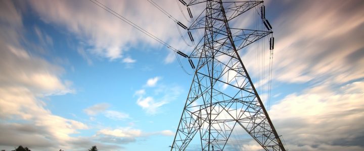 Mammoth power lines with blue sky and clouds behind