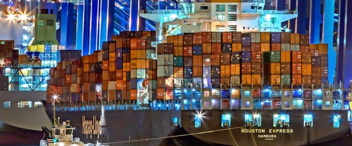 Freight ship stacked high with shipping containers at the dock