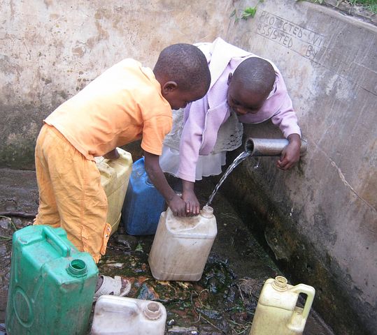 Children in Africa filling containers with water
