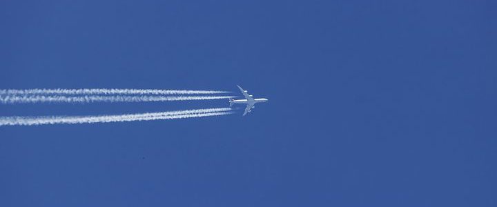 Airplane from below, very distant, with vapor trail