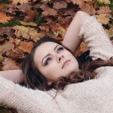 Woman laying on fall leaves