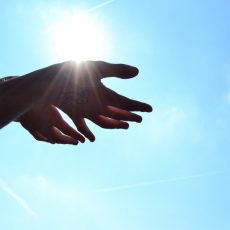 hands under sun with blue sky