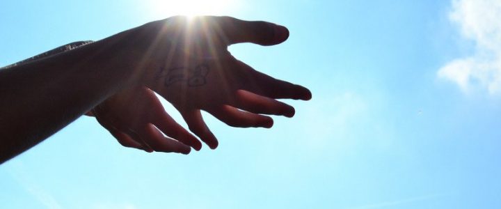 hands under sun with blue sky