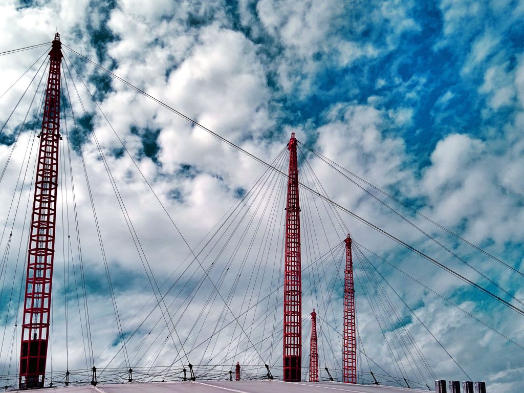 Red bridge against a cloud-filled sky. 