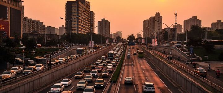 Highways with heavy traffic leading into a cityscape at sunset