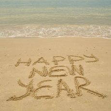 Happy New Year written in the sand at a beach