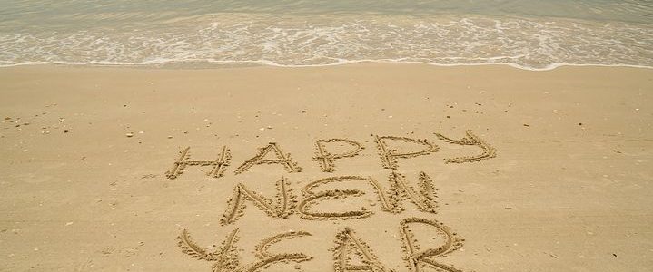 Happy New Year written in the sand at a beach