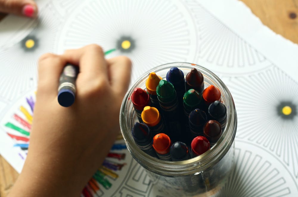 Child's hand coloring with crayons