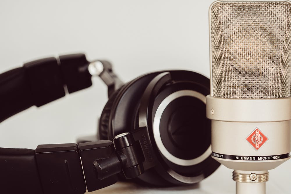 Grey condenser mic and black headphones