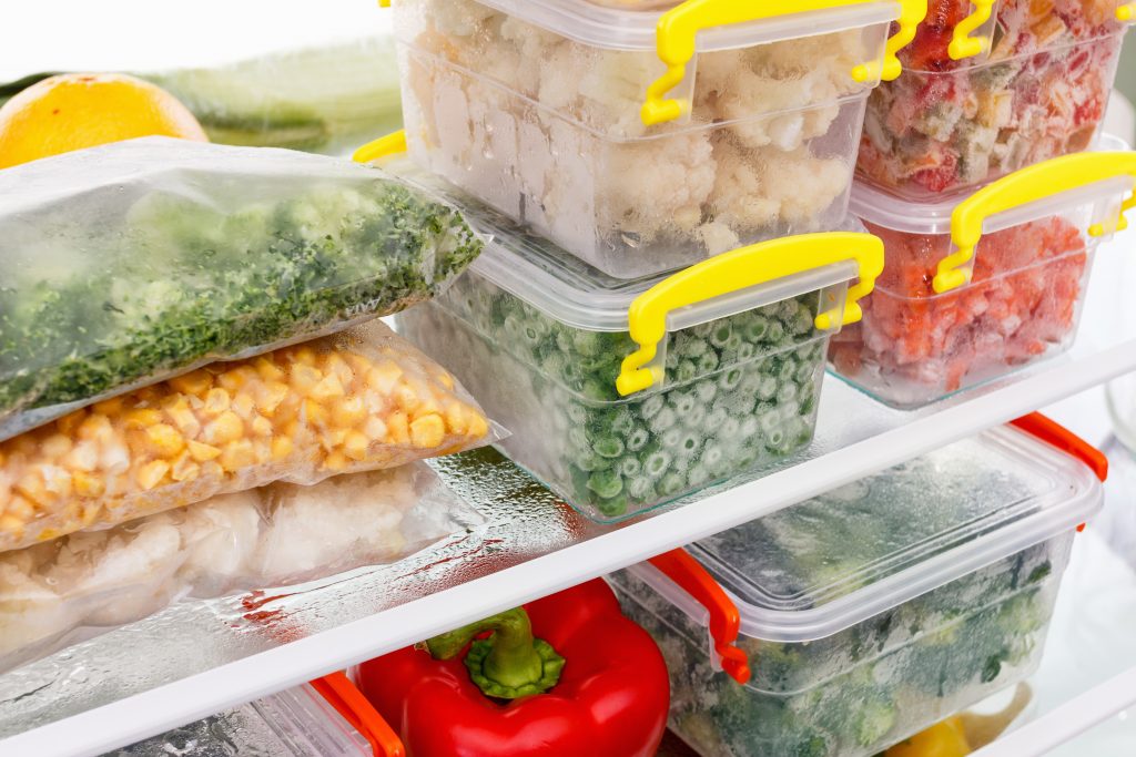 Refrigerator packed with leftovers in containers. 