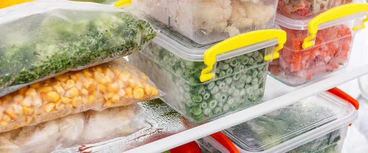 Refrigerator packed with leftovers in containers.