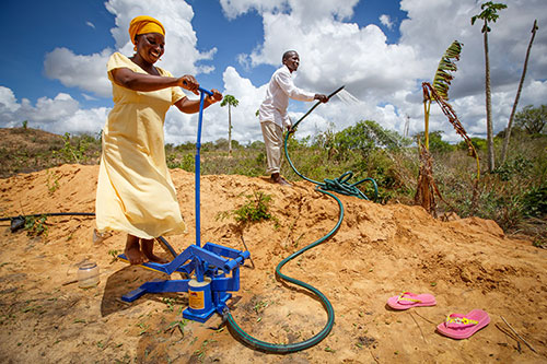 Woman operates a pedal pump n Kenya to irrigate her field. Borehole and pipeline installed in 2013 by World Vision