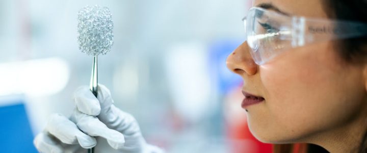 Woman in lab with clean tech battery. Clean tech innovations