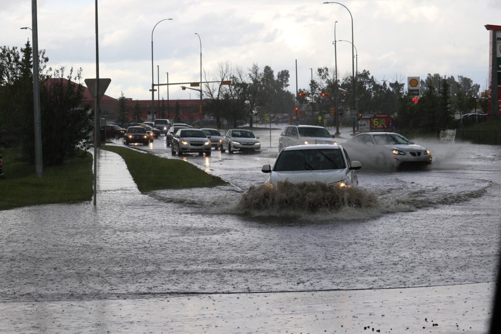 Very flooded roads with cars trying to get across