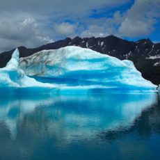 Landscape image of very blue glacier over still water