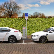Two electric vehicles charging at a station