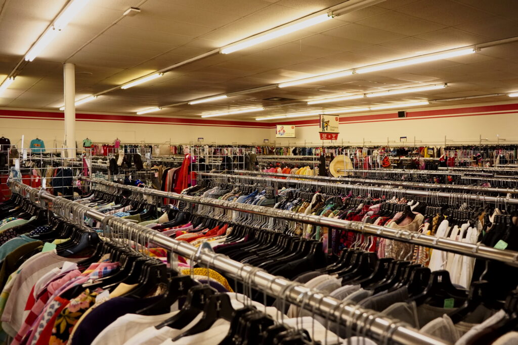 High angle shot of a charity store, rows and rows of full clothing rails.