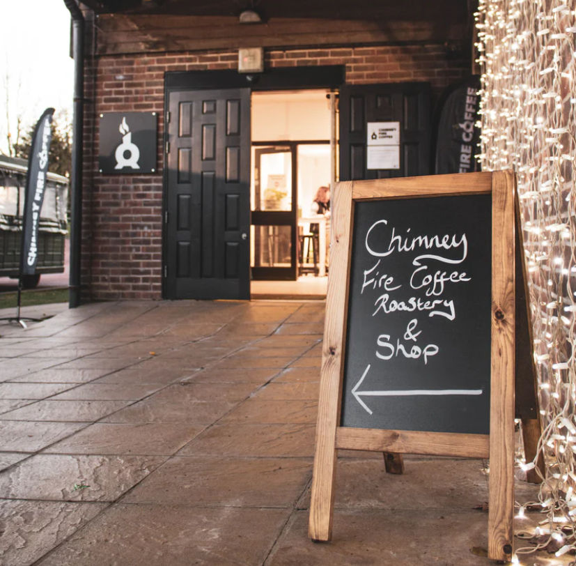 Front entrance of Chimney Fire Coffee, sustainable coffee house, in the UK. Warm red brick building