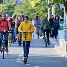 people riding scooters and bicycles in a cycle lane