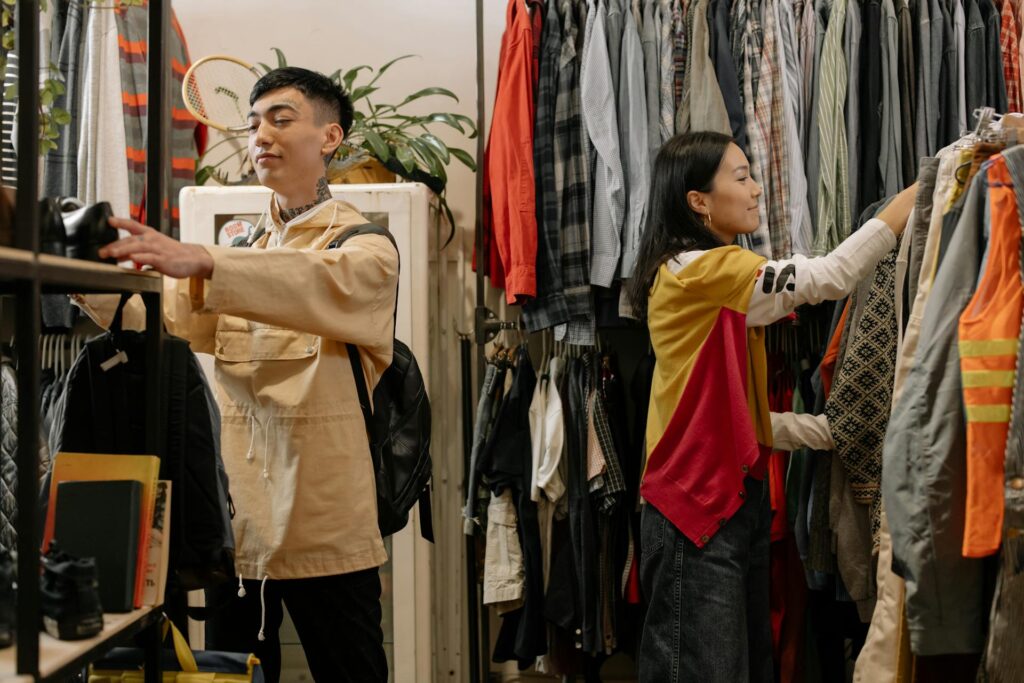 Young Asian man and woman looking at various items in a thrift store.