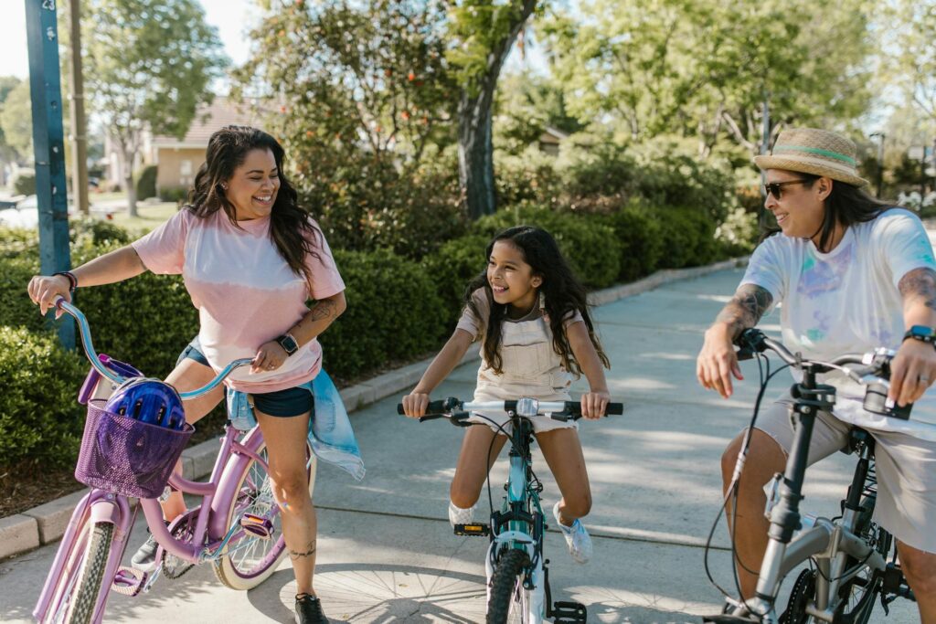 Mom, dad and daughter riding bicycles, smiling and looking happy.