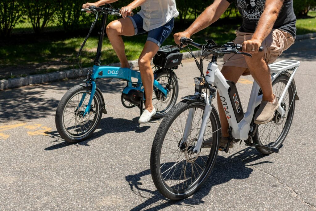 2 people riding electric bikes on a sunny day. One form of micromobility.