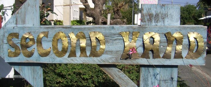 Second hand sign, made with metal on a wooden post