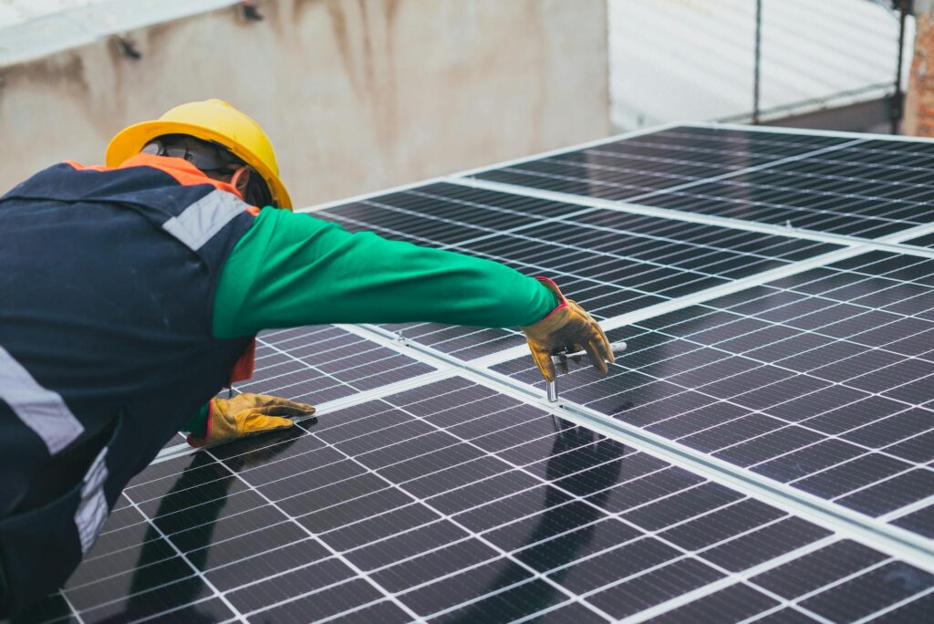 Man installing solar panels on a roof